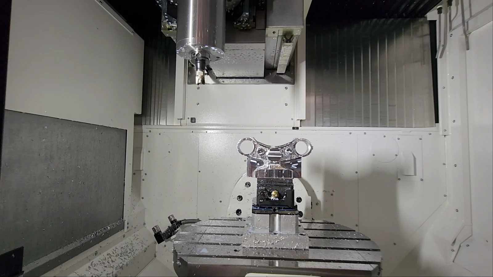 Workpiece clamped on the tilting rotary (trunnion) table of a 5-axis machining center